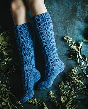 Teal cabled knee-length socks, with flowing cables from calf to toe