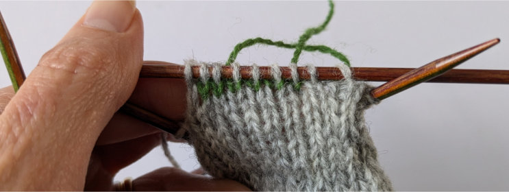 Waste yarn stitches knitted with the main color.